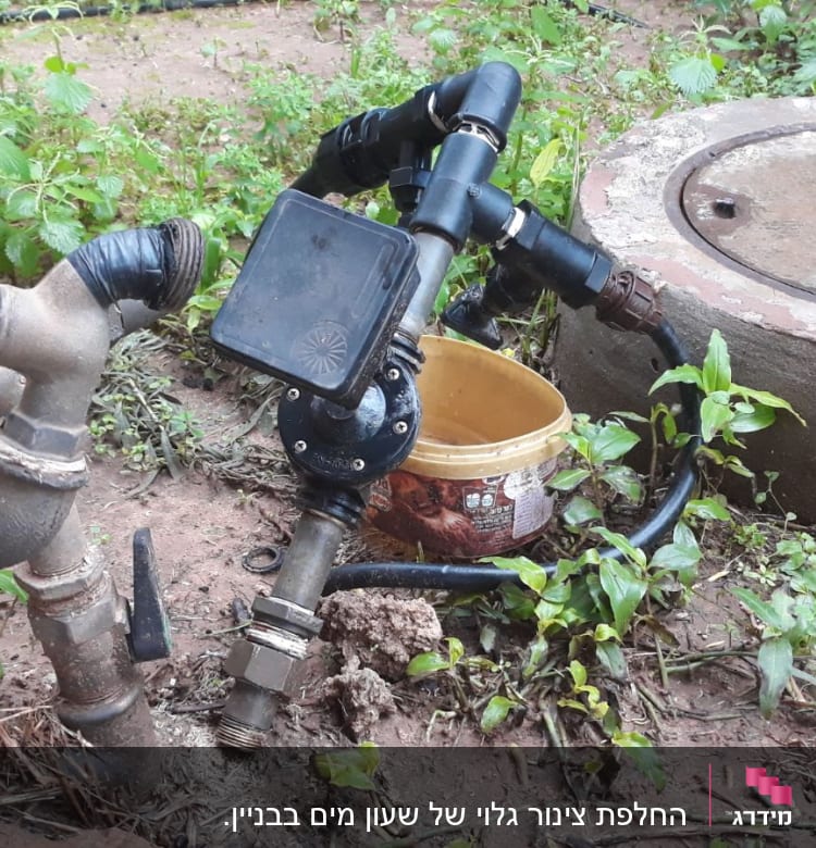 ברזים וצינורות מחוברים עם סרט שחור בגינה